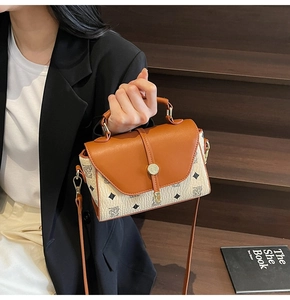 Detail of vintage patterned crossbody bag with brown leather flap on a professional model