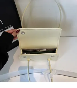 Detail view of the cream shoulder bag interior showing spacious compartments and magnetic closure