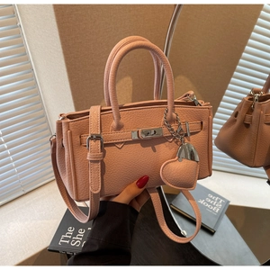 Pink lychee grain leather handbag with gold turn-lock and cute heart charm detail