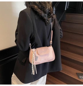 Close-up of pink faux leather square bag with snake skin texture and woven rope tassel