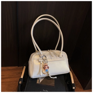 Detail der weißen minimalistischen Pillow Bag mit Doppelreißverschluss und Anhänger
