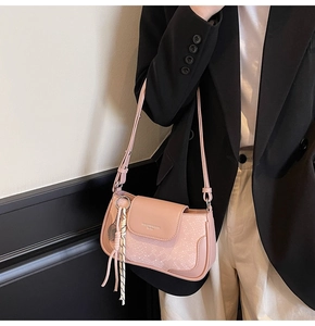 Pink crossbody bag featuring snakeskin texture detail and tennis racket charm