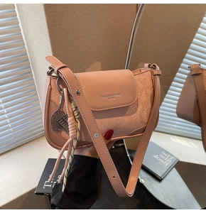 Pink crossbody bag detail with snake pattern texture and mini tennis racket pendant