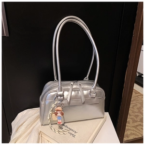 Details einer silbernen Metallic-Achseltasche mit Reißverschluss und Anhänger