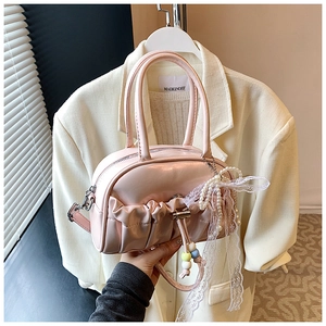 Pink pleated bowling bag detail with lace bow and pearl charm showing mini PU leather texture