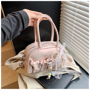 Detailed view of pink pleated handbag with lace pearl bow and bead charms in a trendy style