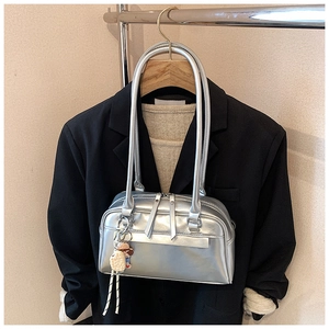 Schicke silberne Baguette-Tasche mit Herzanhänger in einem modischen Lagen-Outfit