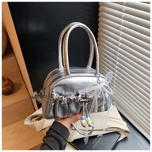 Detail of silver pleated bowling bag with pearl lace bow charm and smooth leather handles