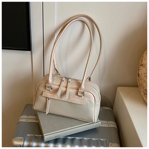 Nahaufnahme der beigen Boston-Tasche mit langen Griffen und Reißverschlussdetails im Detail