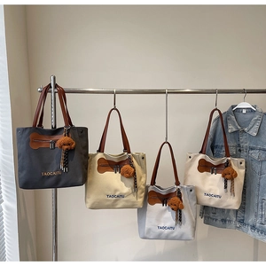 Bolsos tote de lona en cuatro colores colgados con colgantes de perro y asas de cuero