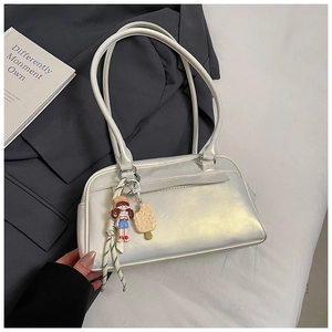 Detail der perlweißen Schultertasche mit niedlichem Cartoon-Mädchen- und Eis-Anhänger