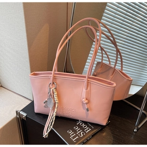 Détail d'un cabas en cuir PU rose avec logo gaufré et breloque raquette de tennis