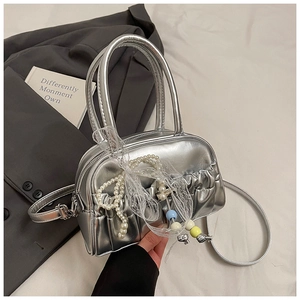 Detail of silver pleated Boston bag featuring pearl chain and colorful bead charms