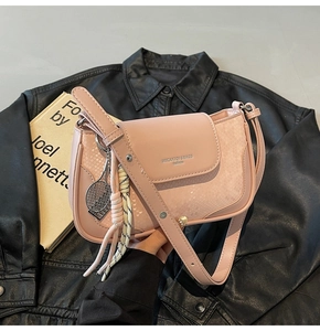 Pink shoulder bag detail showing faux leather crocodile texture and a tennis racket charm