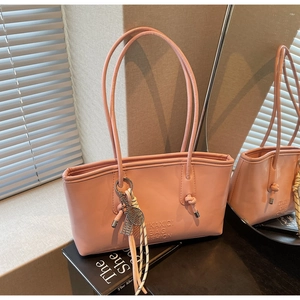 Détail du sac cabas rose verni avec logo gaufré et breloque raquette de tennis en métal