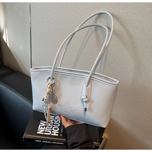 Détail du sac cabas bleu clair en PU avec logo embossé et pendentif de tennis décoratif