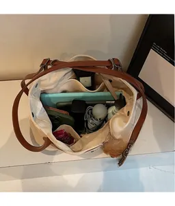 Vista superior que muestra la gran capacidad interior del bolso de lona con objetos diarios