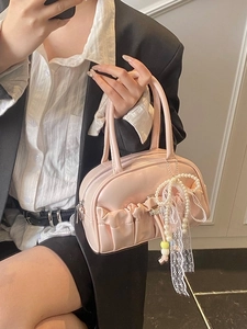 Pink pleated bowling bag with pearl lace pendant shown in a stylish mirror selfie