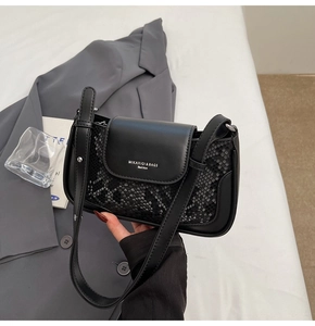 Detail of black faux leather bag showing snakeskin texture and silver embossed logo