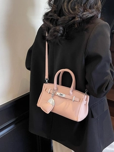 Pink lychee texture mini handbag with heart charm and shoulder strap shown on model