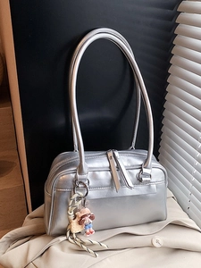 Schicke silberne Schultertasche in minimalistischer Form mit einem mit Cartoon-Anhänger