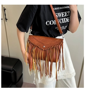 Detail of bohemian fringe crossbody bag with bicolor tassels and triangular metal buckle flap