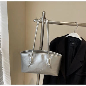 Détail du sac cabas en similicuir argenté avec gaufrage tendance et nœud élégant