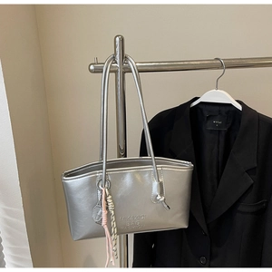 Détail du sac cabas argenté métallisé avec logo et accessoire de charme raquette de tennis