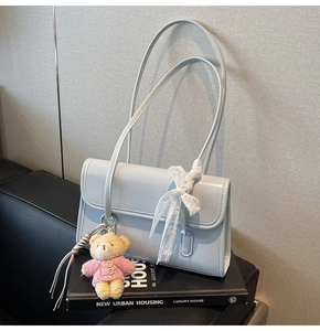 Light blue faux leather underarm bag with white lace bow and cute teddy bear charm