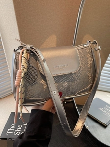 Silver snakeskin pattern shoulder bag with a woven charm and adjustable strap