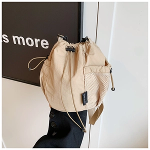 Close-up of khaki nylon bucket bag with side mesh pocket and adjustable drawstring