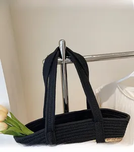 Detail showing the woven texture and durable shoulder strap of the black straw tote bag