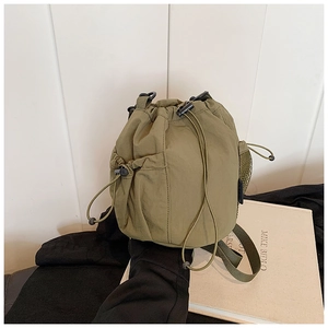 Detail view of army green nylon bucket bag with mesh side pocket and drawstring closure