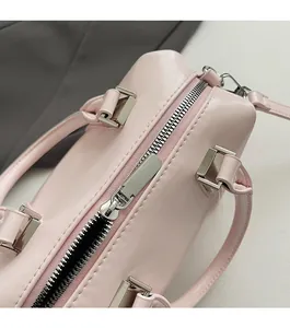 Detail of smooth silver zipper and leather texture on a pink bowling handbag
