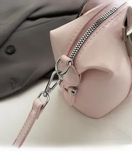 Detailed close-up of pink leather Boston bag featuring high-quality silver metal hardware