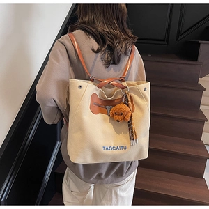 Detailed back view of a versatile cream canvas tote bag with brown leather straps