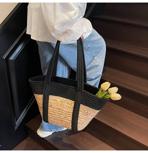 Texture détaillée d'un sac cabas en paille tissé à la main avec anses en corde noire