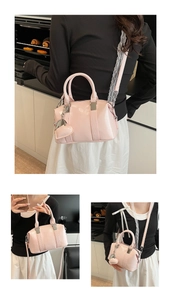 Detailed view of pink patent leather Boston bag with lace strap and heart charm decor