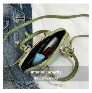Innenkapazität der hellgrünen Muscheltasche mit Kosmetik und verstellbarem Riemen