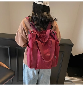 Detail of burgundy versatile backpack showing drawstring closure and side storage pocket