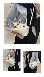 Detailed view of white glossy bowling bag with heart charm and silver hardware