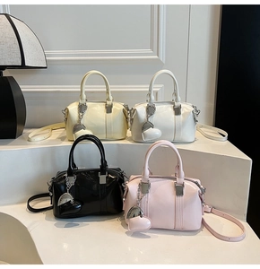 Multiple glossy Boston bags in pastel colors arranged on a white tiered display stand