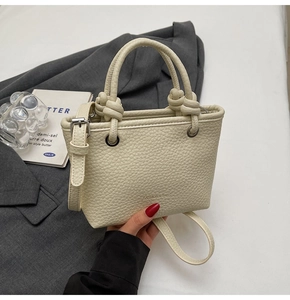 Detail of off-white lychee texture leather mini tote with knot handle and silver hardware
