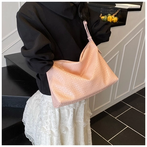 Detail of pink woven large shoulder bag with soft texture and chic hobo style design