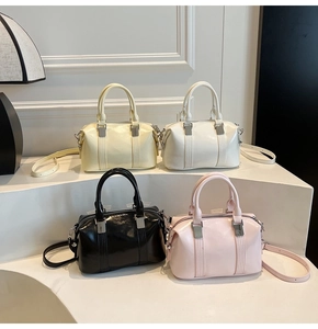 Detailed display of four Boston handbags in beige, cream, black and pink on a white stand