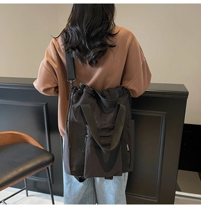 Detail of multi-functional black nylon tote bag with wide straps and side pocket