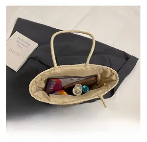Detailed interior of large woven straw tote featuring fabric lining and zipper pocket