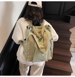 Detailed view of light green nylon multifunctional backpack with side brand label