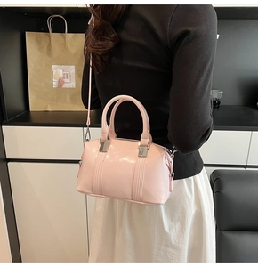 Detail of pink polished bowling bag showing glossy texture and silver metal hardware