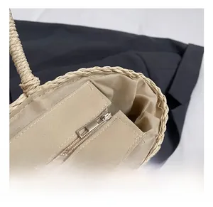 Detail of bohemian straw bag featuring durable silver metal zipper and fabric lining